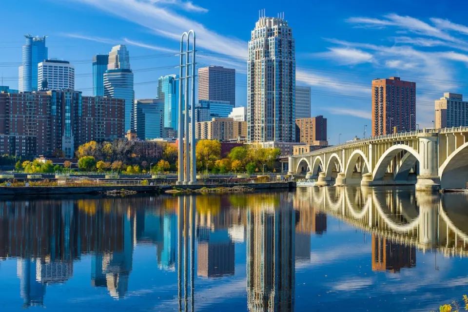Minneapolis, Minnesota skyline with river and bridge in foreground.